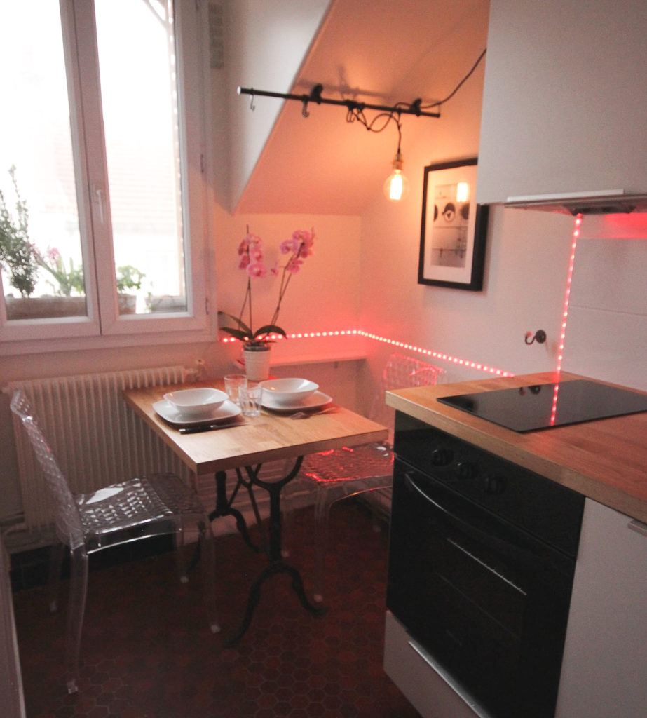 Un appartement 2 pièces complètement rénové et transformé en appartement haussmannien. Coin repas avec guirlande led multicolore pour donner un style tendance et chaleureux