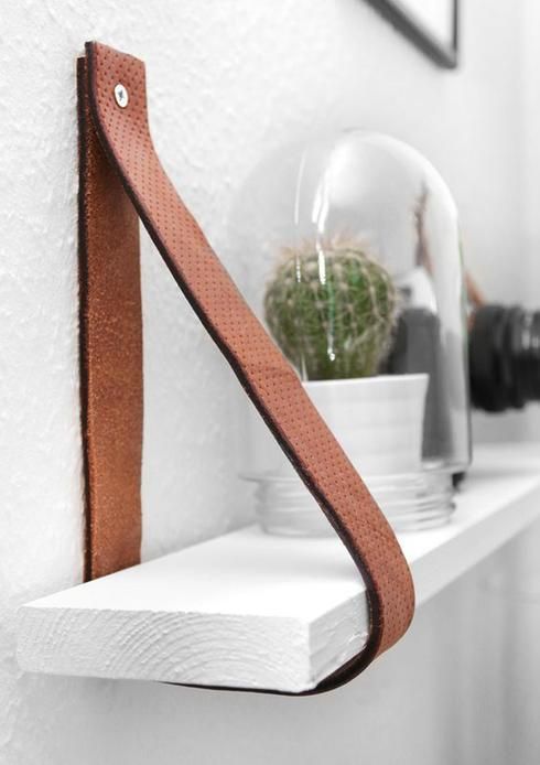 how to use upcycling in home decor : leather straps used as shelf holders